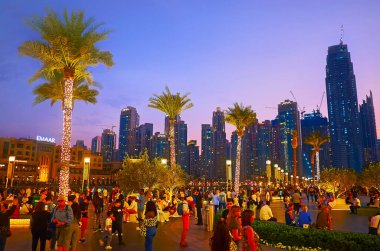 DUBAI, BAE - 7 Mart 2020 'de, 7 Mart' ta Dubai 'de palmiye ağaçları ve gökdelenlerle süslenmiş Burj Halife Gölü' nün kalabalık seti