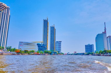 Chao Phraya nehri boyunca ilerleyen feribotla Bangkok, Tayland gibi sayısız modern yamaçlar boyunca.