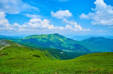 Mavi gökyüzünün altında yeşil Smotrych ve Eared Stone dağları tüylü beyaz bulutlar, Chornohora Sıradağları, Karpatlar, Ukrayna