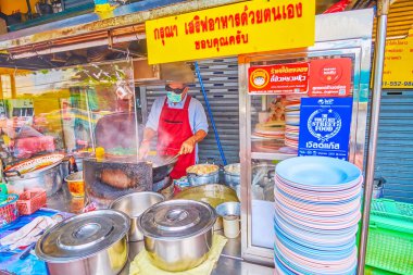 BANGKOK, THAILAND - 12 Mayıs 2019: Aşçı 12 Mayıs 'ta Bangkok, Tayland' da Çin Mahallesi 'ndeki açık mutfakta büyük bir tavada yemek hazırlar.