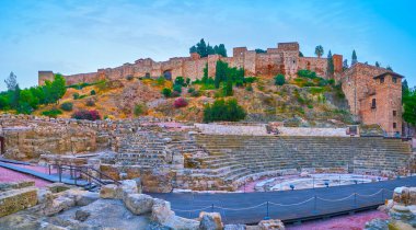 Teatro Romano (Roma Amfitiyatrosu) harabeleri ve ortaçağ Alcazaba Malaga kalesi sabah erken saatlerde, tepenin üstünde, Andalusia, İspanya