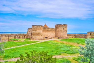 Yeşil çimlerle kaplı geçit alanı, taş surların kalıntıları ve Ortaçağ Akkerman Kalesi 'nin korunmuş Kalesi, Bilhorod-Dnistrovskyi, Ukrayna