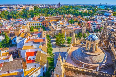 Seville Katedrali 'nin Giralda çan kulesi Katedral' in kubbesine, şehir çatılarına, dar sokaklara ve İspanya 'nın Alcazar Kalesi' nin ortaçağ surlarına bakıyor.