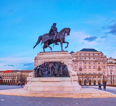 Parlamento binasının yan duvarı ve Lajos Kossuth Meydanı 'nda bulunan Gyula Andrassy binicilik anıtı, arka planda Budapeşte, Macaristan' da klasik sarı tramvay bulunuyor.