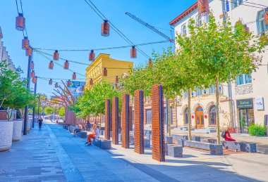 DNIPRO, UKRAINE - 24 Ağustos 2021: 24 Ağustos 'ta Dnipro Dnipro' da bulunan sevimli Korolenko caddesinde metal tesisleri olan banklarda rahatlayın