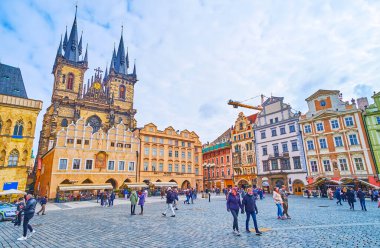 PRAG, CZECH REPUBLIC - 5 Mart 2022: Eski Kasaba Meydanı, Tyn Kilisesi önünde 5 Mart 'ta korunmuş ortaçağ kasaba evleri ve seçkin Gotik Meryem Ana ile övünüyor