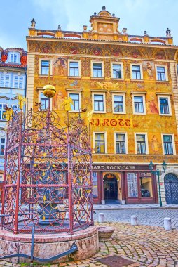 PRAGUE, CZECH REPUBLIC - 5 Mart 2022 Prag Eski Şehir Bölgesi 'nin Küçük Meydanı' ndaki küçük çeşme ve zengin dekore edilmiş U Rotta Evi, 5 Mart 'ta Prag' da