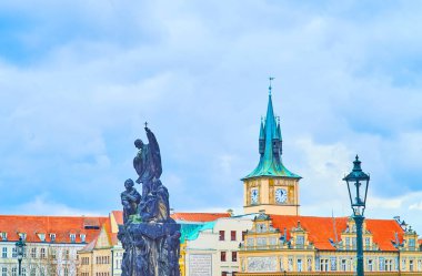 Francis Xavier 'in tarihi heykeli Charles Köprüsü' nde Gotik saat kulesinin ve zengin dekore edilmiş konakların önünde, Prag, Çek Cumhuriyeti