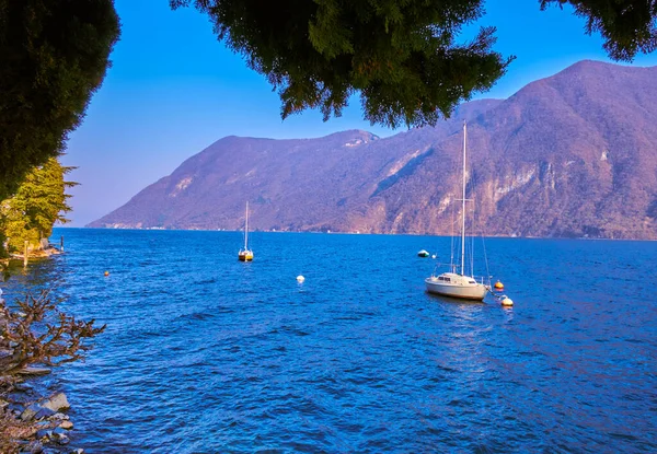 Lugano Gölü 'ndeki yatların manzarası akşam ışıkları, İsviçre