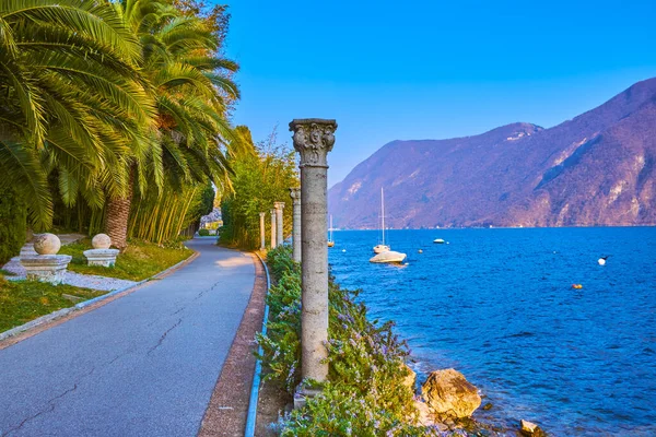 Lugano Gölü kıyısındaki Villa Heleneum parkında deniz manzarası ve diğer taraftaki dağlar, Lugano, İsviçre
