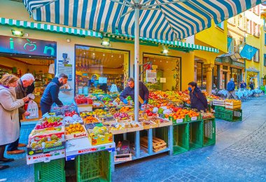 LUGANO, SWitzERLAND - 25 Mart 2022: 25 Mart 'ta Lugano' da taze portakal, elma, kivi, nar ve diğer meyvelerin bulunduğu büyük meyve tezgahı