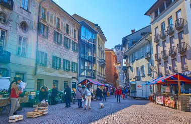 BELLINZONA, SWitzERLAND - 19 Mart 2022: Tarih meydanı Cumartesi Çiftçi Pazarı sırasında 19 Mart 'ta İsviçre' nin Bellinzona kentinde kalabalık bir yer haline gelir.