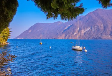 Lugano Gölü 'ndeki yatların manzarası akşam ışıkları, İsviçre