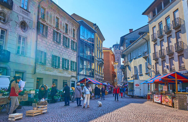 BELLINZONA, SWITZERLAND - MARCH 19, 2022: The historical square becomes a crowded place during Saturday Farmer's market, on March 19 in Bellinzona, Switzerland
