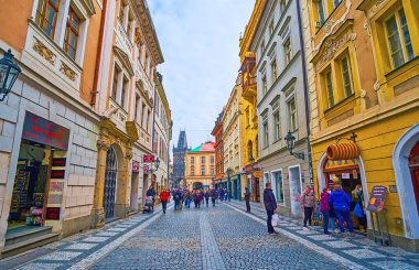 PRAG, CZECH REPUBLIC - 5 Mart 2022: Renkli binalar, küçük kafeler, hediyelik eşya dükkanları ve arkadaki toz kulesi ile tarihi Celetna Caddesi, 5 Mart 'ta Prag' da