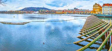 Smetana Embankment 'ten Vltava Nehri' nin Panoraması 'nın arka planında tahta bariyer Charles Köprüsü, St Vitus Katedrali ve Petrin Tepesi manzarası, Prag, Çek Cumhuriyeti