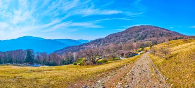 Alpe Vicania montane çayırı Lugano Prealps, Vico Morcote, İsviçre 'nin manzaralı yamaçlarını ve tepelerini gözlemler.