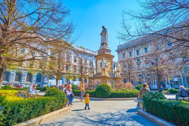 MILAN, ITALY - 5 Nisan 2022: Pietro Magni 'nin Leonardo da Vinci anıtıyla Piazza della Scala' nın ortasındaki küçük park, 5 Nisan 'da İtalya' nın Milano kentinde