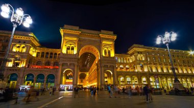 MILAN, ITALY - 5 Nisan 2022: 5 Nisan 'da İtalya' nın Milano kentinde Galleria Vittorio Emanuele II 'nin gece aydınlatmalı manzaralı cephesi