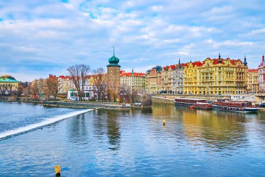 Masaryk Embankment 'ın renkli binalarının önündeki taş Sitkov Su Kulesi' nin önünde Vltava Nehri, Prag, Çek Cumhuriyeti