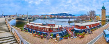 Vltava Nehri 'nin panoramik manzarası, seti, Jirasek Köprüsü, Sitkov Su Kulesi, tekne otelleri ve restoranları, Smichov bölgesi ve karşı kıyıdaki Petrin Tepesi, Prag, Çek Cumhuriyeti