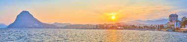 Lugano Gölü 'nün üzerindeki günbatımının panoraması, San Salvatore Dağı ve Lugano şehrinin merkezi bölümü, İsviçre
