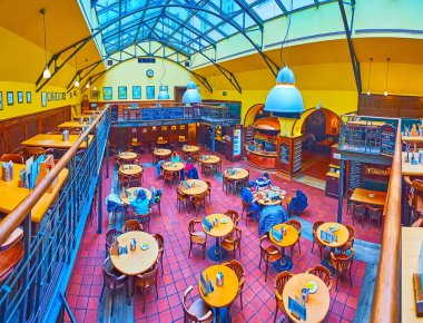 PRAG, CZECH REPUBLIC - 5 Mart 2022: Prag 'da 5 Mart' ta, U Vejvody Pub restoranının cam çatılı, büyük vintage salonlu ve üst teraslı panoramik iç mekanı