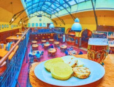 PRAG, CZECH REPUBLIC - 5 Mart 2022: U Vejvody 'nin iç mekanı Knodel kaynamış hamur köfteleri ve Pilsner Urquell birası ile 5 Mart' ta Prag 'da masada.