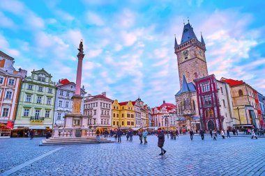 PRAGUE, CZECH REPUBLIC - 5 Mart 2022: Marian Sütun üzerinde parlak günbatımı gökyüzü, konutlar ve Eski Şehir Meydanı 'nda 5 Mart' ta, Prag 'da yer alan Eski Şehir Saat Kulesi