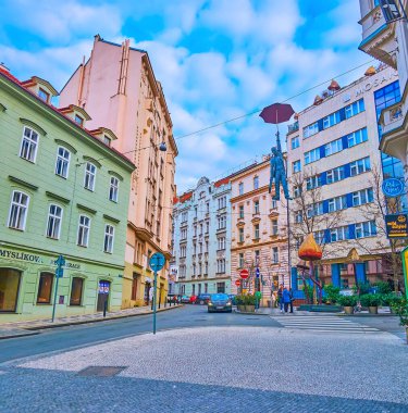 PRAG, CZECH REPUBLIC - 5 Mart 2022: Odboru Caddesi 'nin modern ve tarihi evleri ve Asılı Şemsiye Adam veya Hafif Belirsizlik heykeli ile mimari topluluğu, 5 Mart' ta Prag 'da