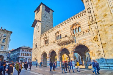 COMO, ITALY - 20 Mart 2022: İnce saat kulesi, atari salonu, sütunlar ve yontulmuş Katedral duvarı ile Broletto Sarayı cephesi (belediye merkezi) 20 Mart 'ta Como' da