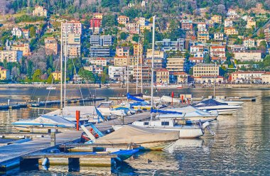 Tekneleri ve yaşam bölgesi olan iskele. Arka planda Como Gölü, Lombardy, İtalya.