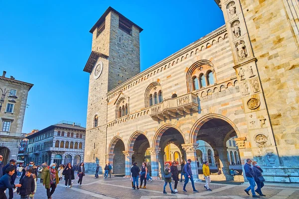 COMO, ITALY - 20 Mart 2022: İnce saat kulesi, atari salonu, sütunlar ve yontulmuş Katedral duvarı ile Broletto Sarayı cephesi (belediye merkezi) 20 Mart 'ta Como' da