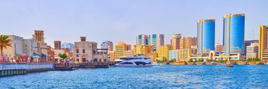 DUBAI, BAE - 1 Mart 2020 Dubai Deresi 'ndeki feribot gezisi, Al Seef bölgesinin kerpiç konutları ve el değmemiş rüzgâr avcıları ile karşı kıyıdaki modern Deira binaları ile 1 Mart' ta Dubai 'de gerçekleşti.