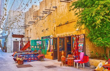 Büyük halı dükkanının dışındaki renkli halı ve halılar, Al Seef mahallesindeki eski kerpiç evinde, Dubai, BAE