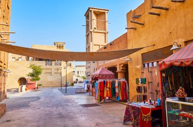 Dubai Heritage Village 'ın dar sokakları, eski kil evlerle dolu, el değmemiş rüzgar yakalayıcıları, kafeler, hediyelik eşya dükkanları, market tezgahları, Dubai, BAE