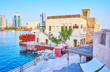 DUBAI, BAE - 1 Mart 2020: 1 Mart 'ta Dubai Deresi' nin arkasında Dubai Rıhtımı 'nda dhow teknesiyle görülen Al Seef ve Deira gökdelenlerinin klasik konutları