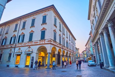 COMO, ITALY - 20 Mart 2022: Cesare Cantu caddesi üzerinden 20 Mart 'ta Como' da taş sütunları, atari salonu ve yardım süslemeleriyle manzaralı tarihi bina