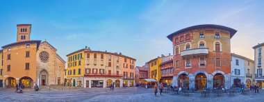 COMO, ITALY - 20 Mart 2022: 20 Mart 'ta Piazza del Mercato del Grano' nun (Tahıl Pazarı Meydanı) ortaçağ konakları, kasaba evleri ve San Fedele Kilisesi 'nin akşam manzarası, Como' da