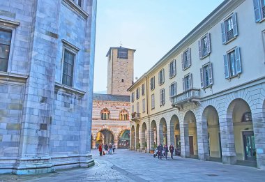 COMO, İtalya - 20 Mart 2022 Dar Via Pretorio caddesi, Broletto Sarayı ve Como Katedrali 'nin kulesi ve atari salonu, 20 Mart' ta Como 'da