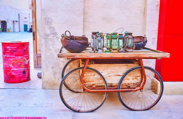 在Al Seef Dubai Uae的房子墙上挂着装有煤油灯和金属碗的老式木制推车 — 图库照片