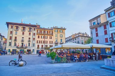 COMO, İtalya - 20 Mart 2022: 20 Mart 'ta Como' da korunmuş tarihi binalar ve pek çok açık kafe ve restoranla güzel Alessandro Volta Meydanı