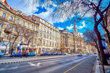BUDAPEST, HUNGARY - 23 Şubat 2022: Macaristan 'ın Budapeşte kentinde 23 Şubat' ta çevredeki binaların olağanüstü mimarisinin keyfini çıkararak Grand Boulevard boyunca yürüyün