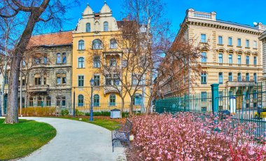 Çiçek açan müze bahçesinin panoramik manzarası ve Budapeşte, Macaristan 'daki tarihi köşkler.