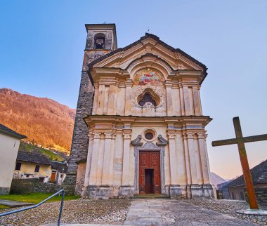 Santa Maria degli Angeli Kilisesi 'nin güzel ortaçağ cephesi freskleri, duvar sütunları, sıva sütunları ve taş saat kulesi, Lavertezzo, Valle Verzasca, İsviçre