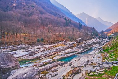 Lepontine Alplerinde keyifli akşamlar. Verzasca Nehri, Lavertezzo, Valle Verzasca, İsviçre 'nin puslu dağları ve kayalık havzası manzaralı.