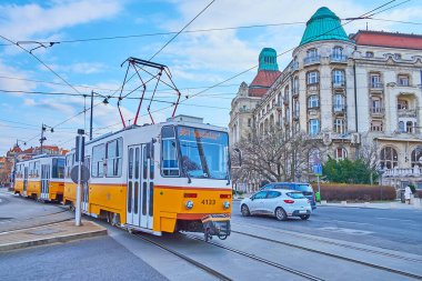 Klasik sarı tramvay Buda, Budapeşte, Macaristan 'daki Aziz Gellert Meydanı' na biniyor.