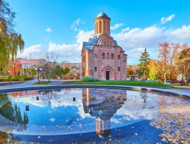 St. Paraskeva (Pyatnytska) Kilisesi ve açık mavi gökyüzü Bohdan Khmelnytsky Park, Chernihiv, Ukrayna 'daki çeşmenin yüzeyine yansımaktadır.