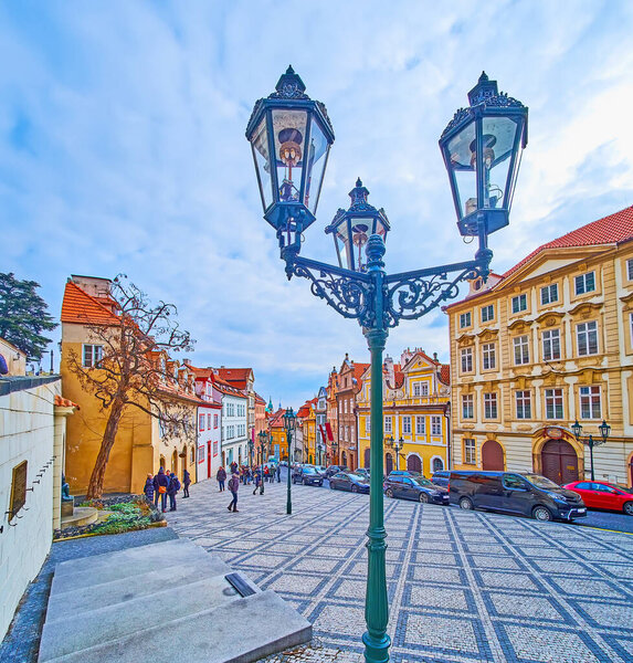 The beautiful vintage lamppost in front of historic housing of historic cobbled Nerudova Street, Prague, Czech Republic