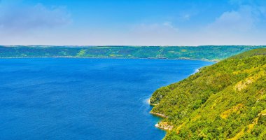 Ukrayna 'daki Podilski Tovtry Ulusal Doğa Parkı' ndaki yemyeşil Dinyester nehrinin yemyeşil yamaçları.